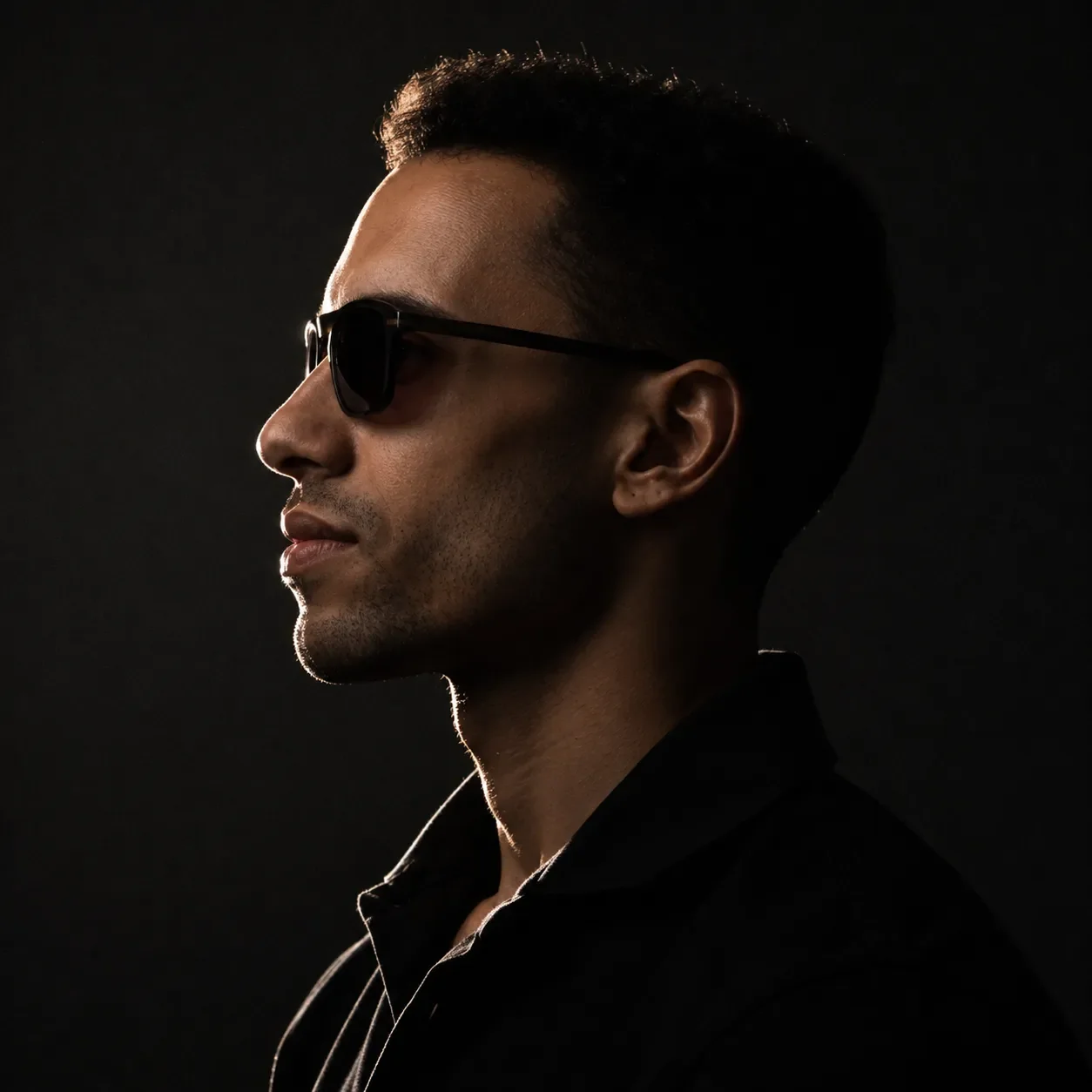 Low-key profile portrait of Ashraf Qopiah